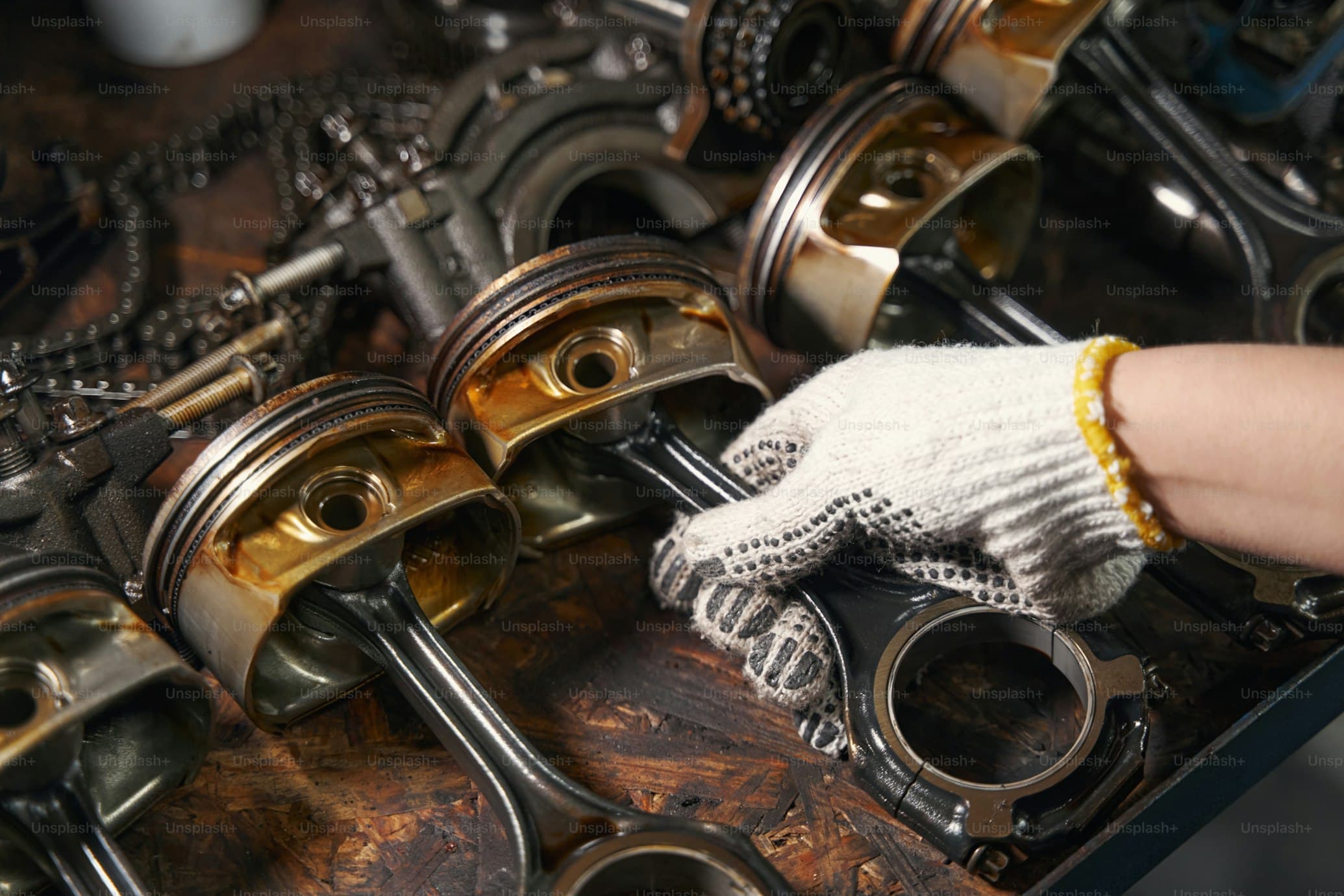 Engine pistons and connecting rods on a workbench during rebuild or tune-up work